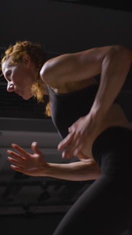 Vertical-Video-Close-Up-Studio-Shot-Of-Mature-Woman-Wearing-Gym-Fitness-Clothing-Doing-Cardio-Exercise